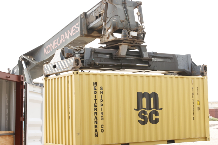 Une grue Konecranes soulève un conteneur maritime jaune de la compagnie MSC.